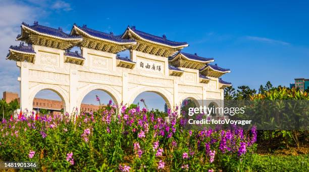 taipei paifang gate in liberty square framed by flowers taipei - taipei landmark stock pictures, royalty-free photos & images