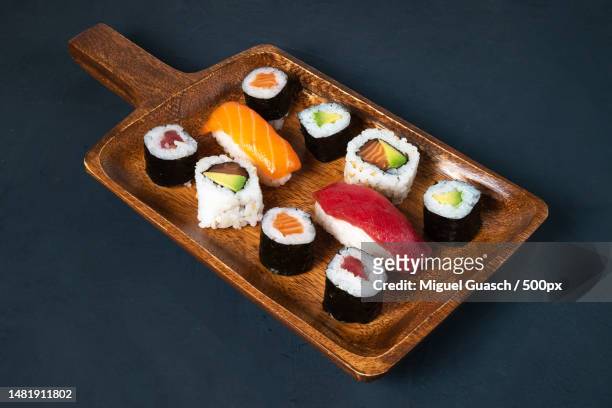 maki sushi board on dark background,barcelona,spain - nori stock-fotos und bilder