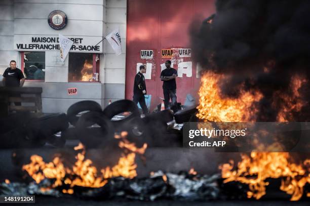 Tires burn as French prison employees protest in front of the entrance of the prison in Villefranche-sur-Saône, central France, on July 12 to...