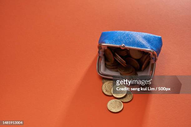 blue color coin purse against orange color background,malaysia - metallic purse fotografías e imágenes de stock