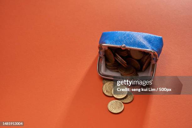 blue color coin purse against orange color background,malaysia - metallic purse photos et images de collection