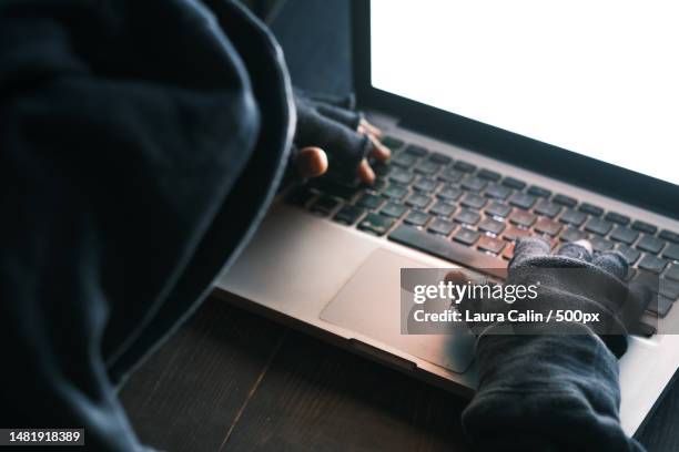 hacker hand stealing data from laptop top down,romania - data breach fotografías e imágenes de stock