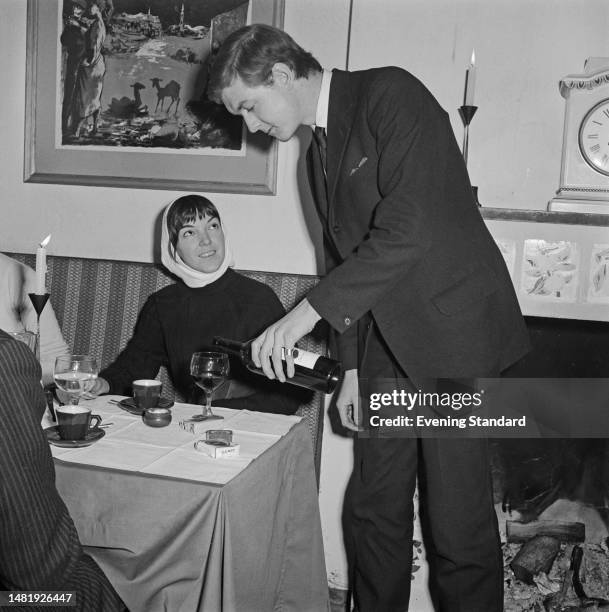 English fashion designer Mary Quant with her husband and business partner Alexander Plunkett-Greene at a table in their restaurant 'Alexander's'...