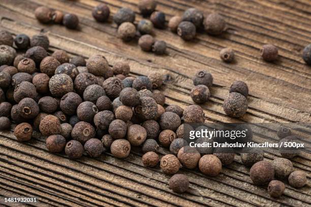 allspice spice on dark rustic wooden background,romania - allspice stock pictures, royalty-free photos & images