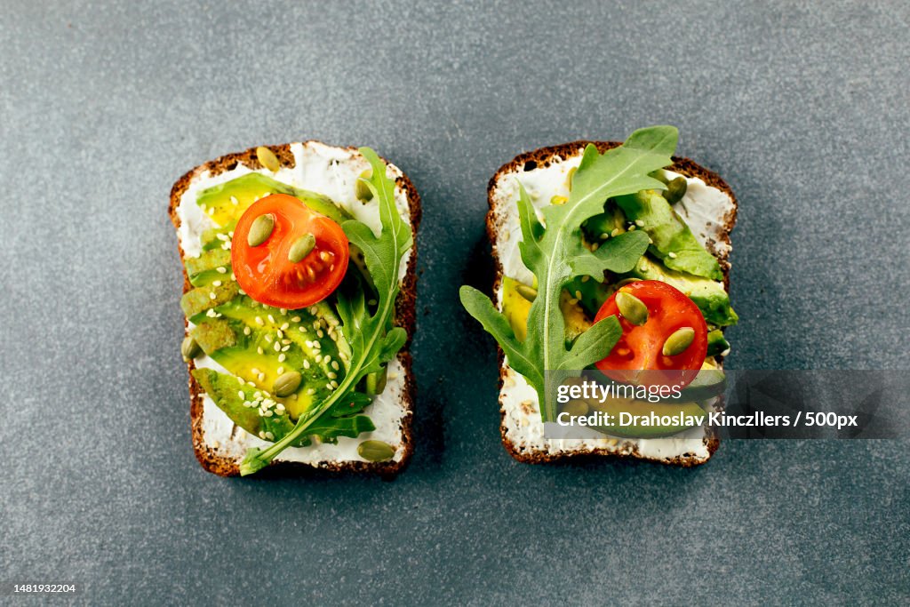 Healthy vegan snack Avocado toasts with cottage cheese,Arugula and tomato Top view,Romania