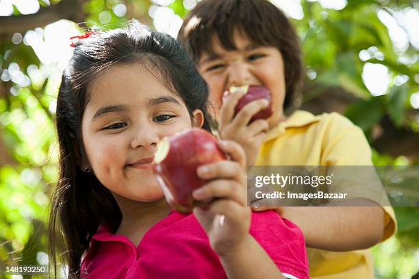 girl and boy (4-7) eating apples - apple fruit stock pictures, royalty-free photos & images