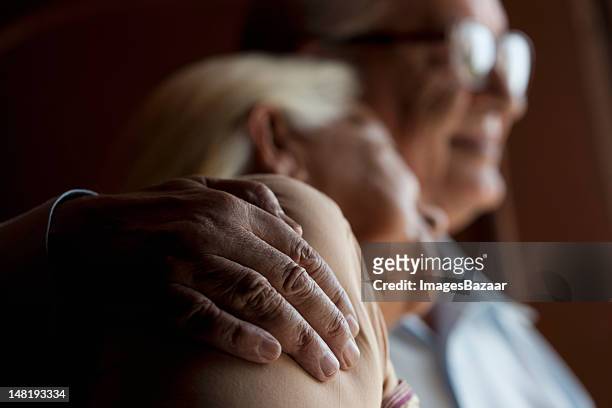 senior coppia abbracciare una persona - toccare foto e immagini stock