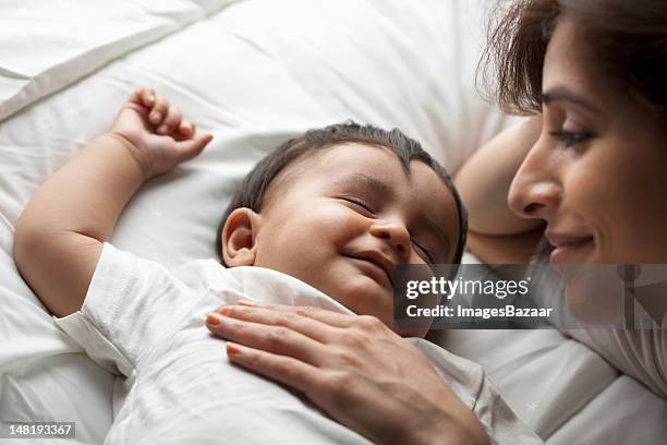 mother with baby son (12-17 months) sleeping - indian baby boy stock pictures, royalty-free photos & images