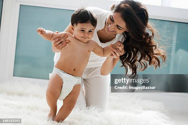 mother teaching baby son (12-17 months) to walk - adult wearing diaper stock pictures, royalty-free photos & images