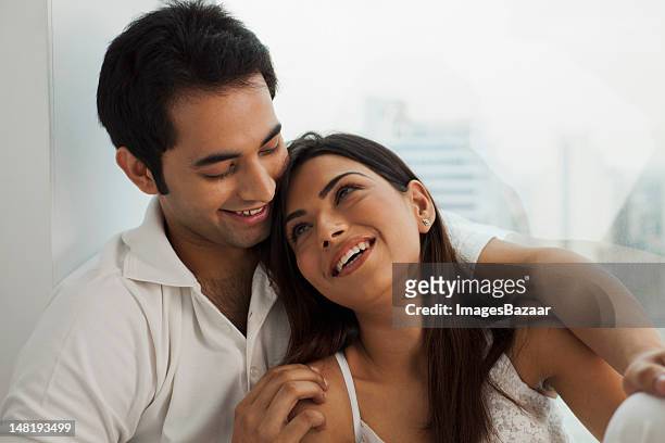 glückliches junges paar entspannende am fenster - india love stock-fotos und bilder