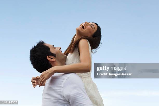 happy young couple playing against blue sky - love stock pictures, royalty-free photos & images