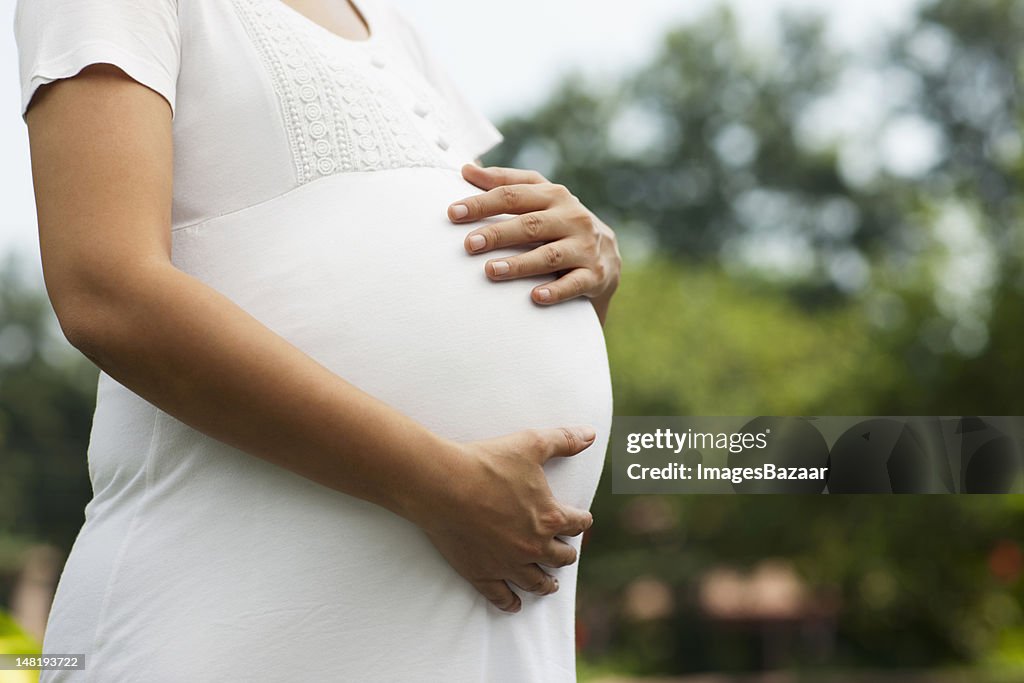 Young pregnant woman touching her belly