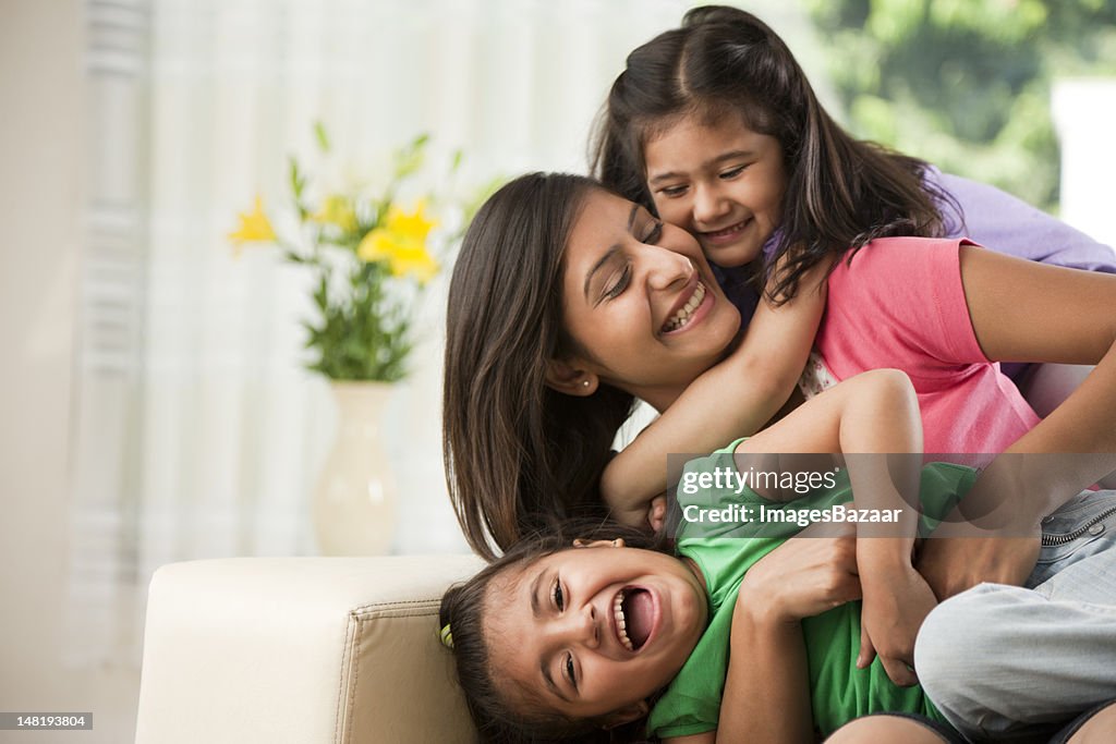 Mother with daughters (6-7) sitting on sofa
