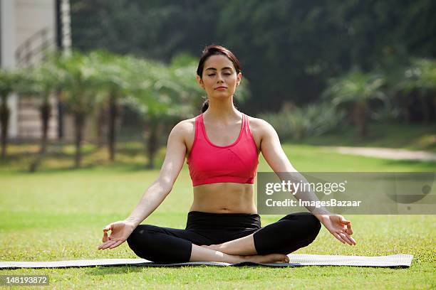 woman sitting in lotos position in back yard - mudra stock pictures, royalty-free photos & images