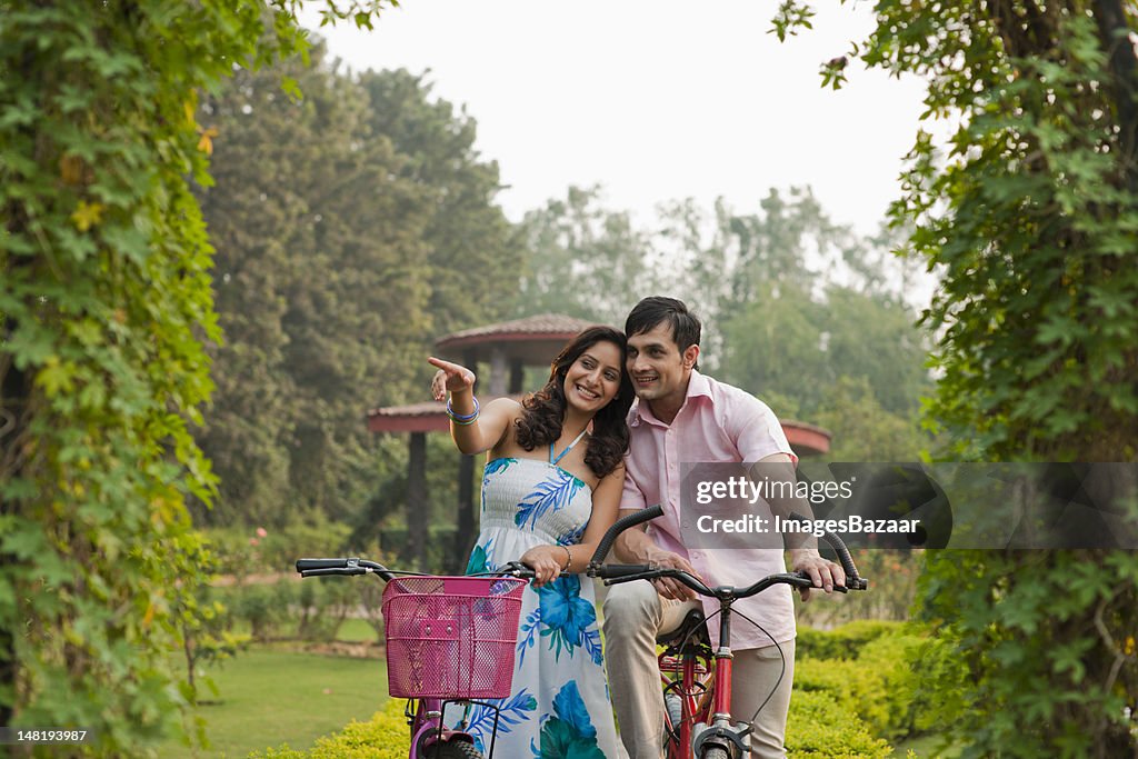 Pareja joven en bicicleta en el parque