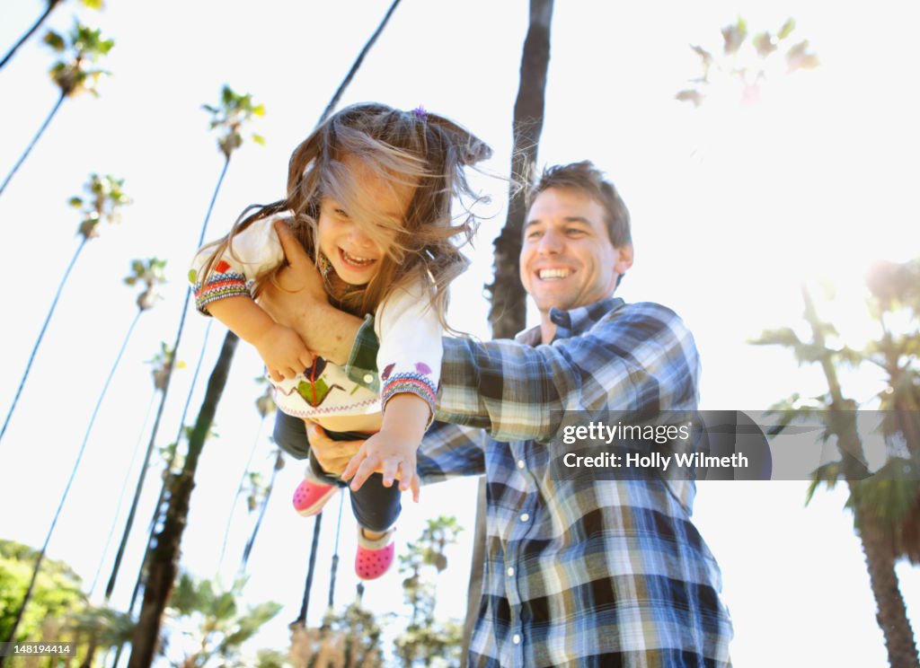 Caucasian father playing with daughter