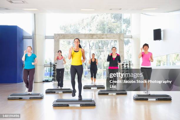 women exercising together in class - auf etwas treten stock-fotos und bilder
