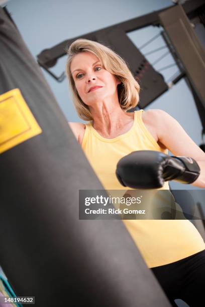 caucasian woman boxing with punching bag - punching bag stock pictures, royalty-free photos & images