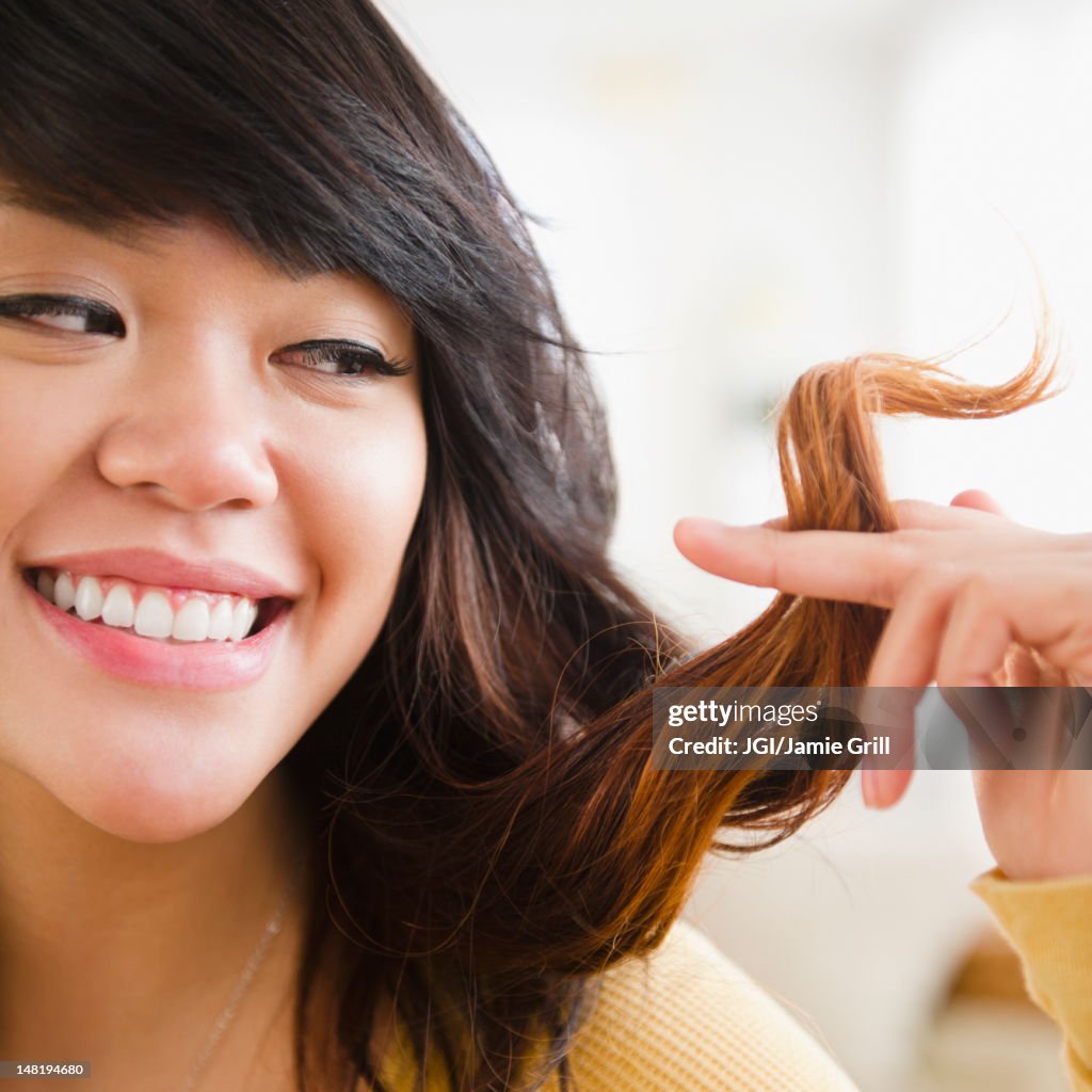 Pacific Islander woman looking at her hair