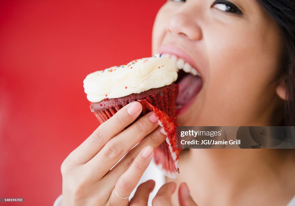 Pacific Islander woman eating cupcake