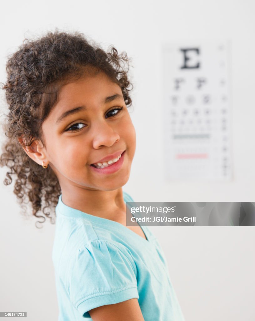 Mixed race girl having an eye exam
