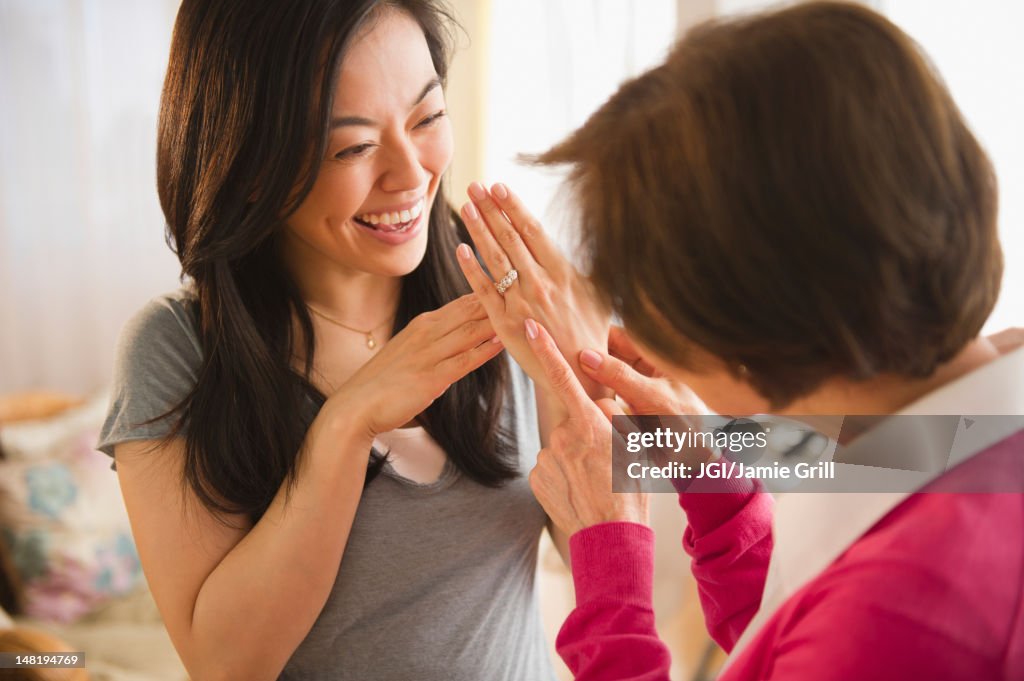 Japanese daughter showing engagement ring to mother