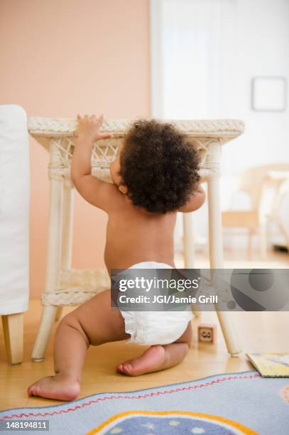 black baby girl pulling up on table - baby climbing stock pictures, royalty-free photos & images