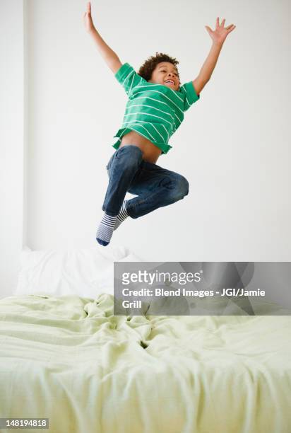 black boy jumping on bed - children jumping bed stock pictures, royalty-free photos & images