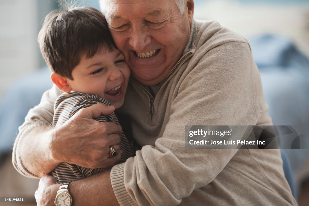 Caucasian man hugging grandson