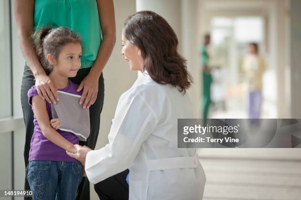 doctor talking to mother and daughter - kind mit armschlinge stock-fotos und bilder
