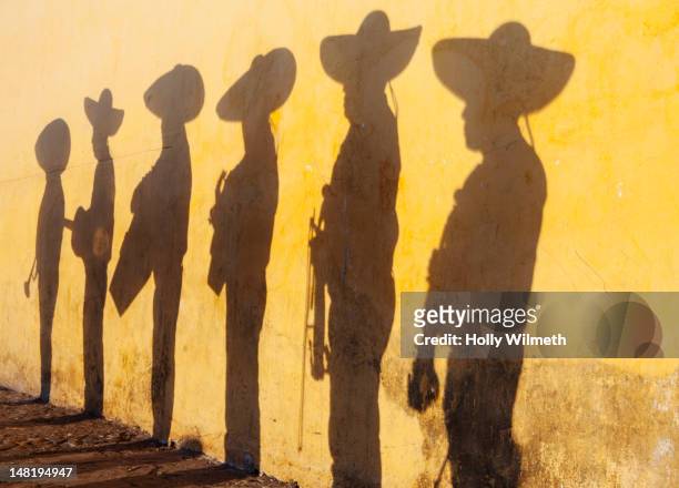 shadows of mariachi band members - san cristobal stock pictures, royalty-free photos & images