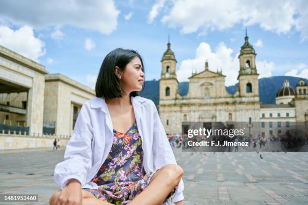 south american woman sitting in bolivar square in bogota - bolivar square bogota stockfoto's en -beelden