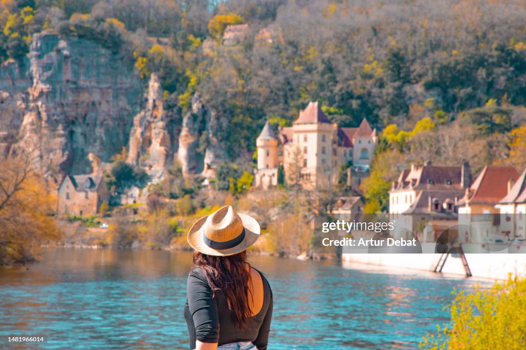 Traveler woman with straw hat in picturesque town in the south of France in the Perigord region.