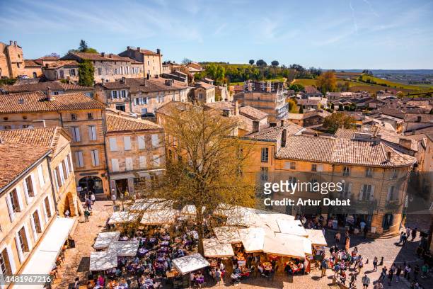 elevated view of the medieval town of saint emilion with tourists in the main square. france - aquitaine stock pictures, royalty-free photos & images