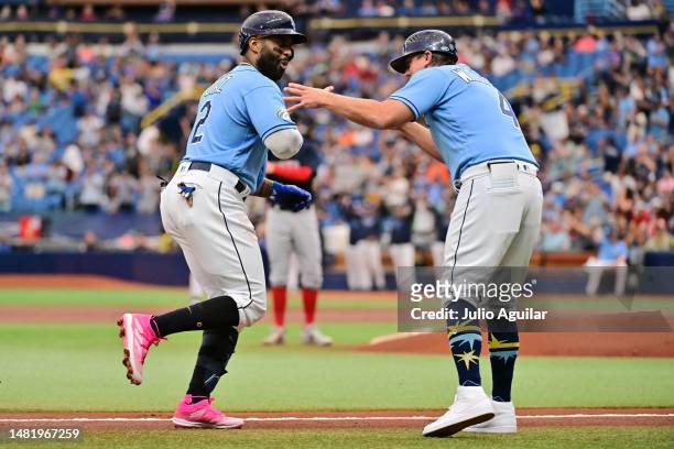 Yandy Diaz celebrates with third base coach Brady Williams of the Tampa Bay Rays after hitting a home run in the first inning against the Boston Red...