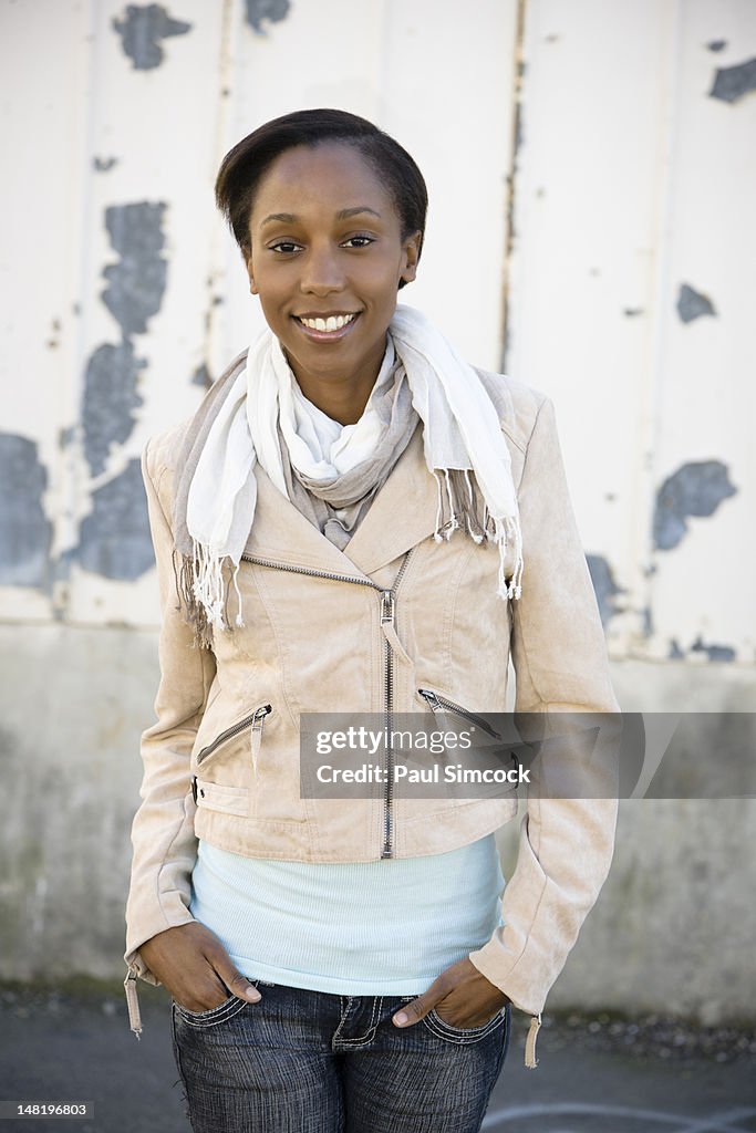 Smiling woman with hands in pockets