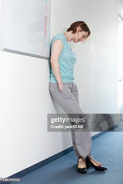 businesswoman taking off shoes in office - fatigue full body stock pictures, royalty-free photos & images