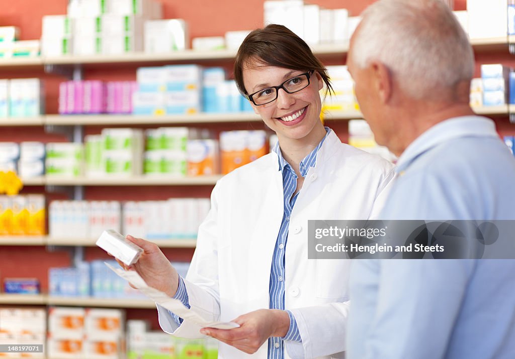 Pharmacist talking to patient in store