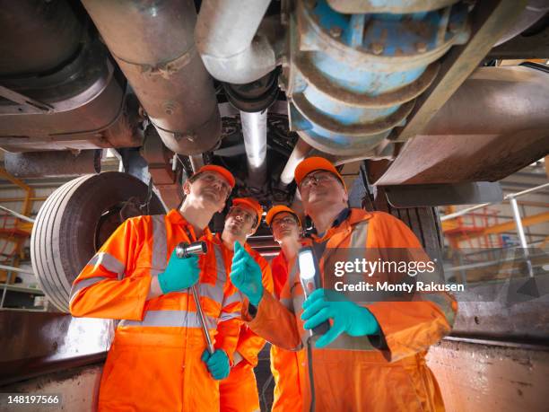 group of apprentice engineers and engineer inspecting underneath truck - undercarriage stock pictures, royalty-free photos & images