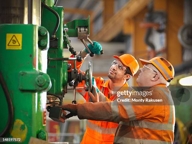 apprentice engineer and engineer working on drill - hefboom stockfoto's en -beelden