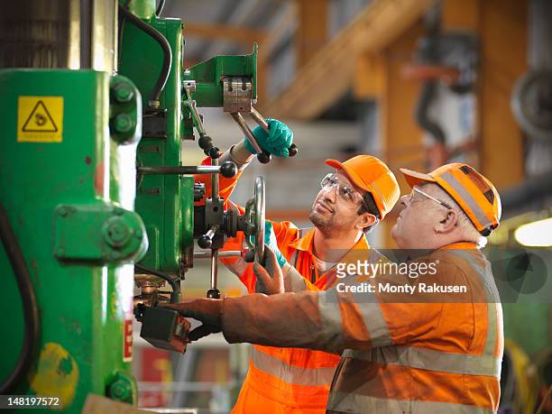 apprentice engineer and engineer working on drill - lever stock pictures, royalty-free photos & images