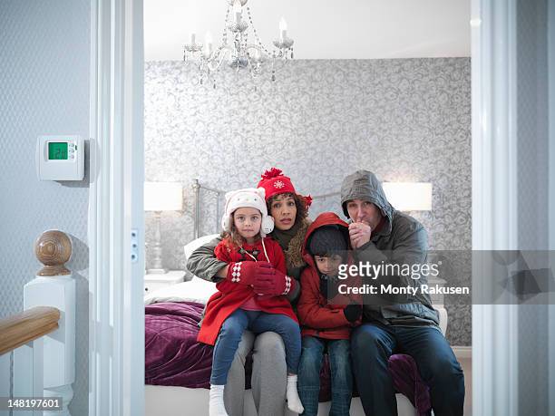 family wearing winter clothing in bedroom of energy efficient house - froid photos et images de collection