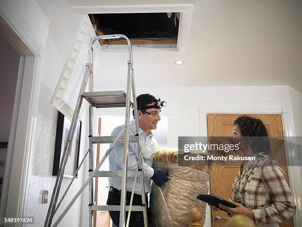 couple discussing loft insulation in home - house insulation not posing stock pictures, royalty-free photos & images