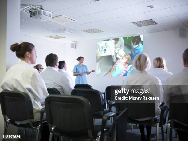 apprentice dentists learning from professional using screen in dentist college - projector classroom photos et images de collection