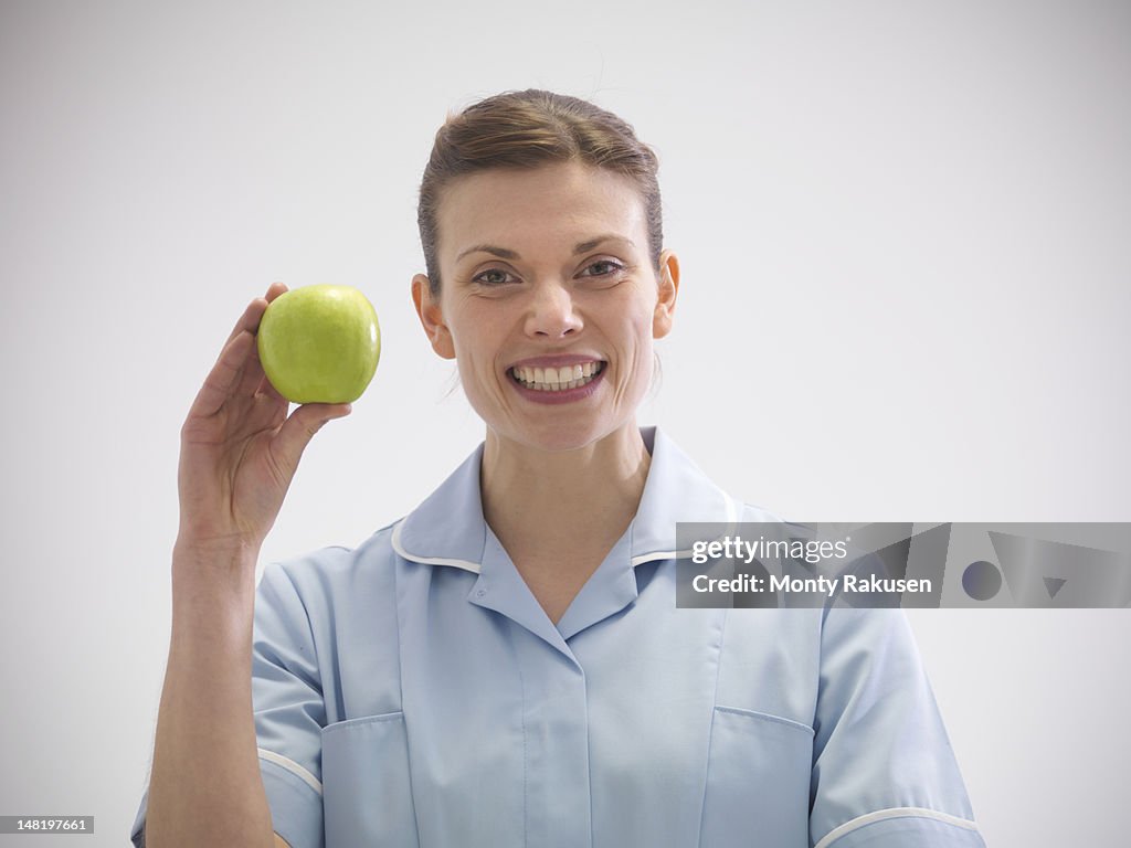 Portrait of smiling dentist holding apple