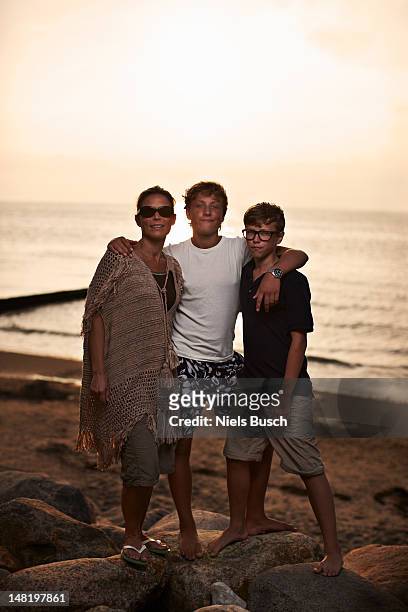 family hugging on beach - teen boy barefoot stock pictures, royalty-free photos & images
