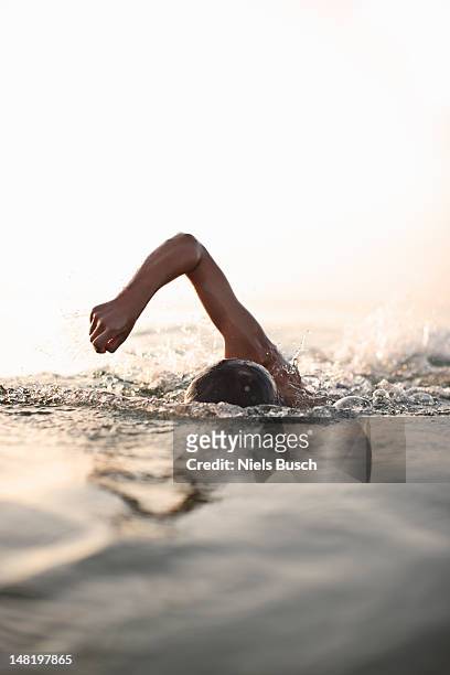 teenage boy swimming en agua - natación fotografías e imágenes de stock