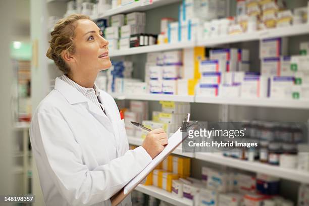 pharmacist writing on clipboard - pharmacist stock pictures, royalty-free photos & images