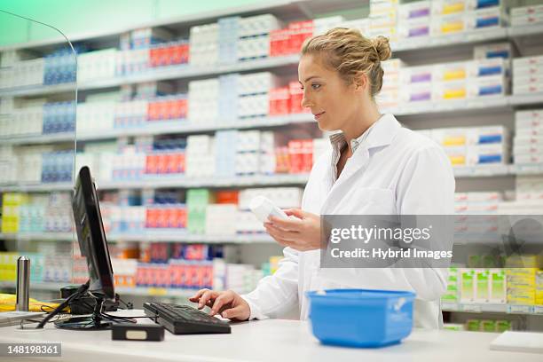pharmacist researching medication - apotheek stockfoto's en -beelden