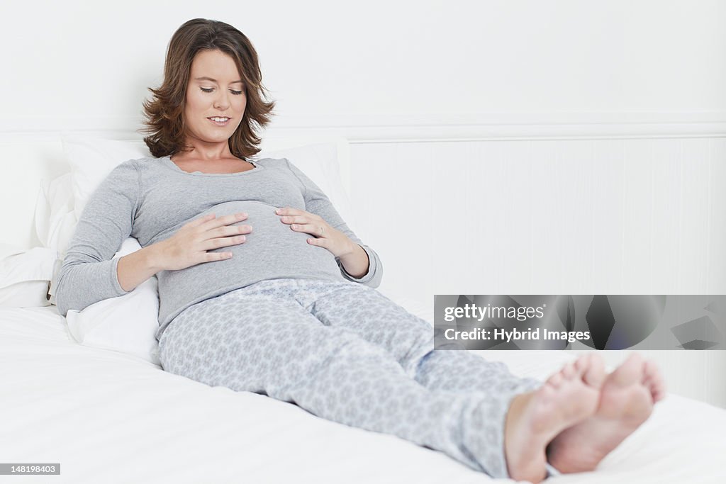 Donna incinta a letto con pancia